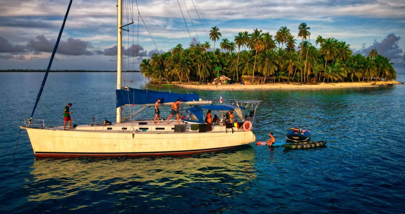 Sailboat anchored off a small palm island