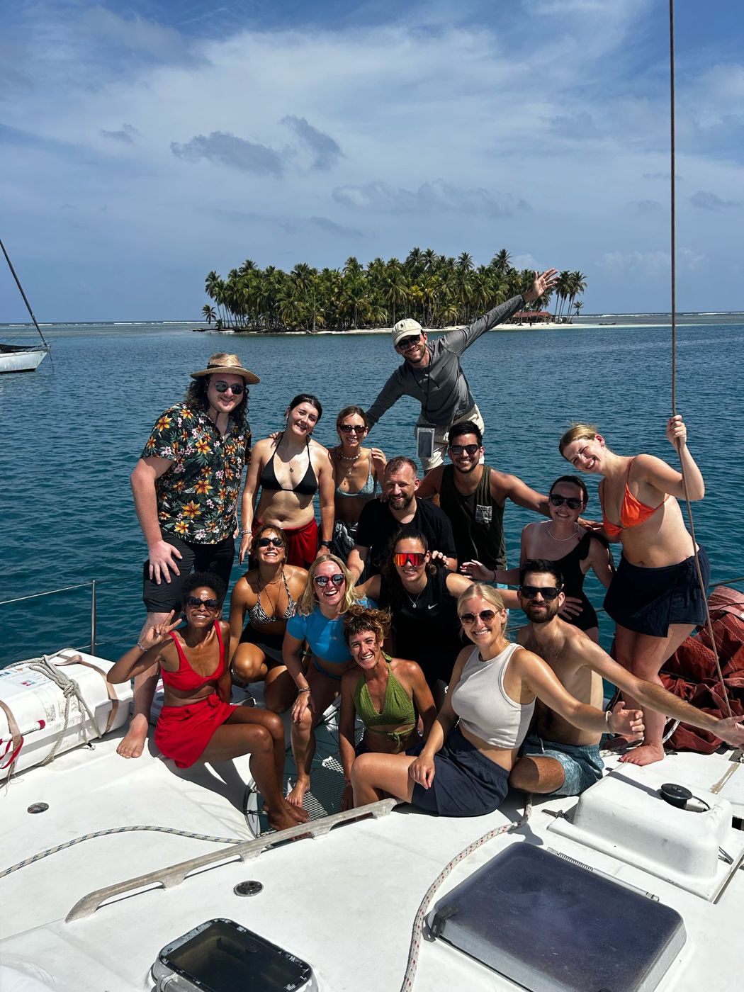 A group of guests smiling on the bow of the boat